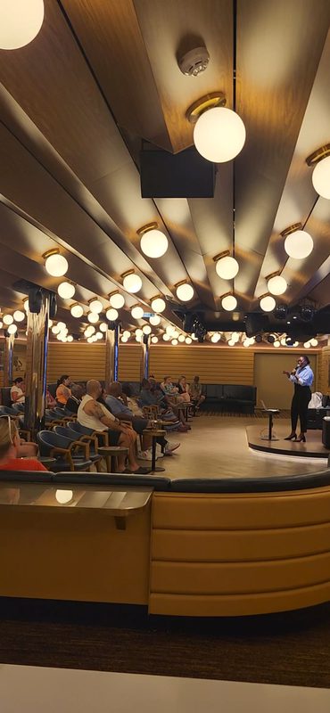 Guests seated in a cruise ship show lounge during a seminar